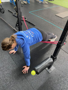 The band across the hips lets us reduce the weight at the bottom of the push up, where it is hardest. We use this frequently when people first shift to the floor for push ups.